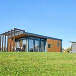 Moderne Ferienhaus mit Terrasse und Garten. Nebenhaus mit Satellitenschüssel.