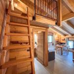 Holztreppe führt zu einer Galerie über dem Essbereich mit Tisch und Stühlen.