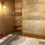 Schlafzimmer mit Holzwand, Kleiderschrank und Bett mit Musterdecke.