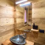 Holzbadezimmer mit Steinwaschbecken und Spiegel