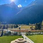 Panorama aus dem Fenster mit Bergen, Wiese und einem Zelt.