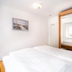 Schlafzimmer mit Doppelbett, Spiegelschrank und Wandbild.