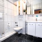 Badezimmer mit Toilette, Waschbecken und Heizkörper