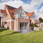 Ferienhaus mit Solaranlage, Balkon und Garten. Modernes Design mit Backsteinfassade.