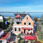 Rotes Backsteinhaus mit Terrasse und Blick aufs Meer.
