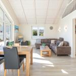 Wohn- und Essbereich mit Sofa, Esstisch und großem Fenster.