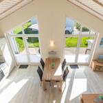 Küche, Essbereich und Wohnzimmer mit großen Fenstern und Holzboden.