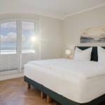 Schlafzimmer mit großem Bett und Blick auf See