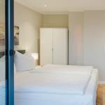 Schlafzimmer mit Doppelbett, Kleiderschrank und Blick in das Badezimmer.