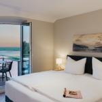 Schlafzimmer mit Balkon und Blick auf Wasser