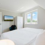 Schlafzimmer mit Bett, Fenster, Kleiderschrank und TV