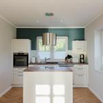 Moderne Küche mit Insel, weißen Schränken und Holzboden.