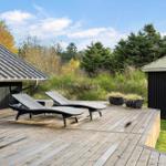 Deck with two loungers and view of forest and sky.