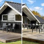 Wooden terrace with table and chairs in front of a house with dark siding and roof.