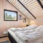 Bedroom with wooden walls, roof window, and bed