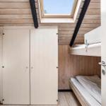 Bedroom with bunk bed, closet, and skylight.