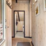 Wood-paneled entryway with pictures and door to the bathroom.
