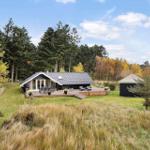 A house with terrace, garden, and forest in the background.