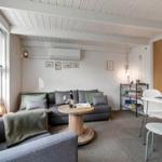 Wohn- und Essbereich mit Sofa, Tisch und Stühlen. Fenster, Decke und Wand sichtbar.