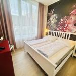 Schlafzimmer mit Bett, Nachttischen und Fenster