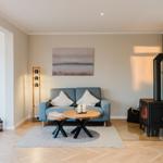 Wohnzimmer mit Sofa, Kamin und Holzboden