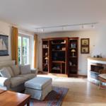 Wohnzimmer mit Sofa, Bücherregal und Kamin