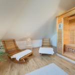 Sauna mit Holzbank und zwei Liegen mit Handtüchern.