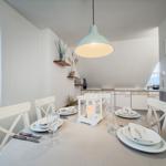 Esstisch mit Stühlen, Lampe und Kerzenhalter im Essbereich.