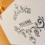 Willkommensschild mit floraler Verzierung an der Tür