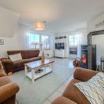 Wohnzimmer mit Sofa, Kamin und Fernseher.