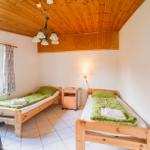 Two single beds, a sofa, window, and wooden ceiling.