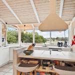 Kitchen with wooden ceiling, large windows, and kitchen island with games.