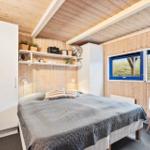 Bedroom with bed, wardrobe, and windows overlooking dunes.