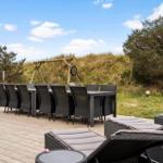 Terrace with table, chairs, and loungers. Background: grass and shrub landscape.