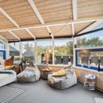 Living area with seating and large window view of the garden.