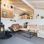 Living area with fireplace, sofa, and coffee table under wooden ceiling.