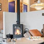 Wood-burning stove, sofa, and table in the living area.