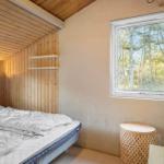 Schlafzimmer mit Bett, Fenster und Holzwand
