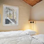 Schlafzimmer mit Bett, Fenster und Wandheizung.