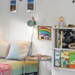 Schlafzimmer mit Bett, Nachttisch, Bücherregal und Wandlampen.