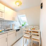 Küche mit Essbereich, Dachfenster und hellen Schränken.