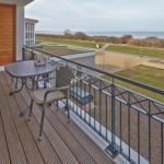 Terrasse mit Tisch und Stuhl, Blick auf Strand und Meer.