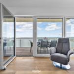 Wohnbereich mit Blick auf das Meer und Balkon mit Sitzgelegenheiten.