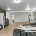 Wohnzimmer mit Sofa, Couchtisch und Fernseher an der Wand.