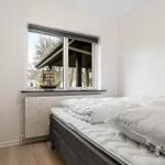 Schlafzimmer mit Bett, Fenster und Schrank. Auf dem Fensterbrett steht ein Schiffmodell.