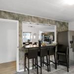 Küche mit Barhockern und Kühlschrank an der Wand