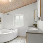 Badezimmer mit Badewanne, Waschbecken und Fenster.