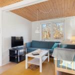 Living room with sofa, TV, and view of forest.
