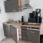 Küche mit Spüle, Herd, Kühlschrank und Mikrowelle.