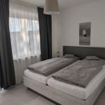 Schlafzimmer mit Doppelbett, Fenster und Wandbild.